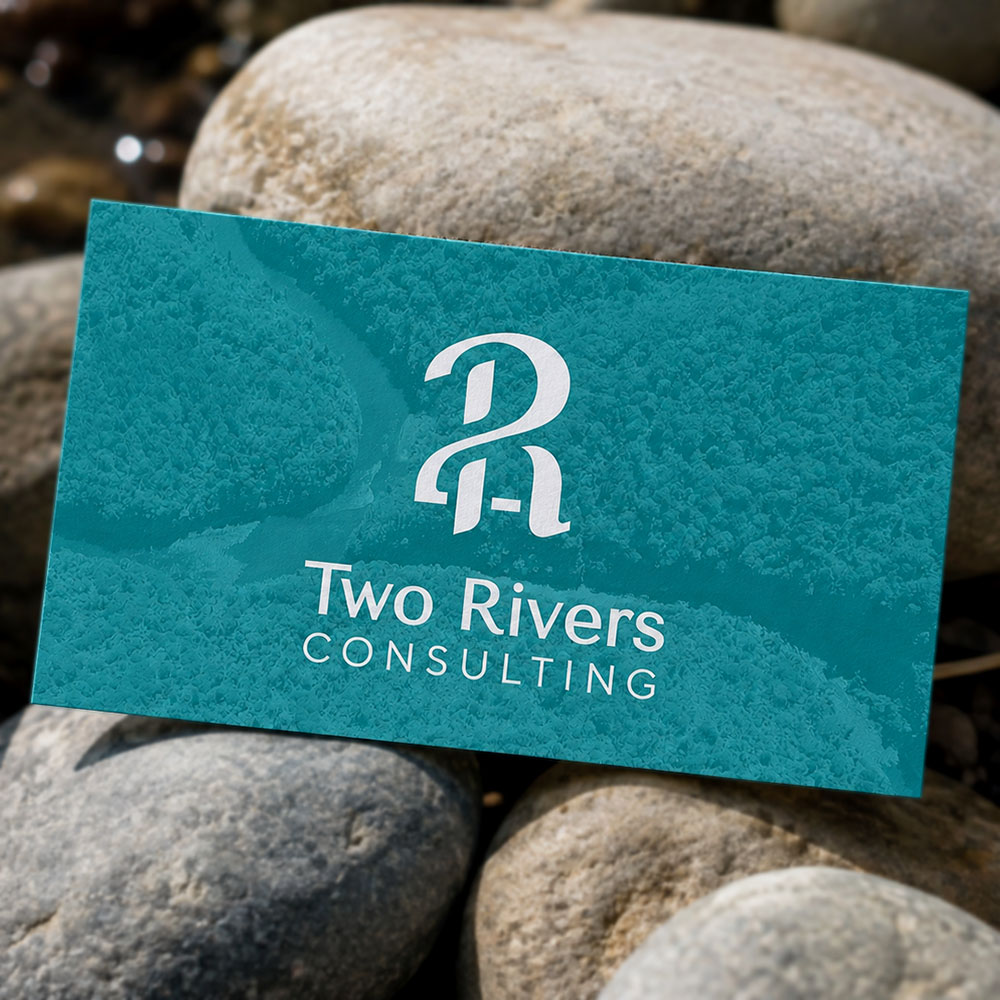 Two Rivers Consulting business card mockup on river stones